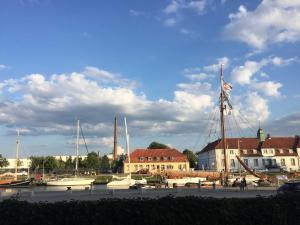 a sail boat docked in a marina next to buildings at Am Hafen 13 in Glückstadt
