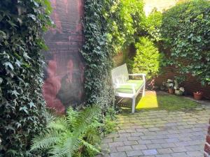 a bench sitting in a garden with ivy at Am Hafen 13 in Glückstadt +28 photos