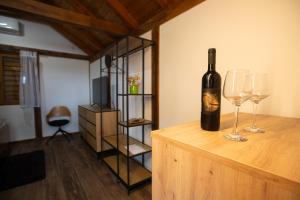 a bottle of wine sitting on a table with two glasses at Savoy Village in Čokadinci