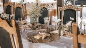 a table with flowers and vases on it at Savoy Village in Čokadinci