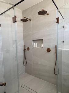 a shower stall with a glass door in a bathroom at בקצה הוואדי - The Wadi Edge in Yeroẖam +42 photos
