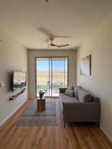 a living room with a couch and a ceiling fan at בקצה הוואדי - The Wadi Edge in Yeroẖam