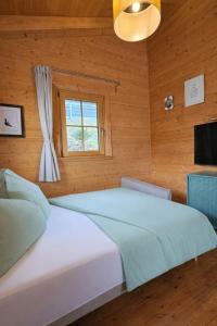 a bedroom with a large white bed and a window at Das Paradieschen Edlitz - stilvolles Blockhaus mit Kamin in Edlitz +13 photos