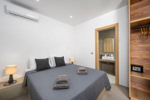 a bedroom with a bed with two towels on it at Villa Salty Sun 6 in Kremasti +10 photos