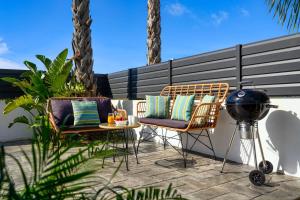 a patio with two chairs and a table and a grill at Villa Salty Sun 7 in Kremasti