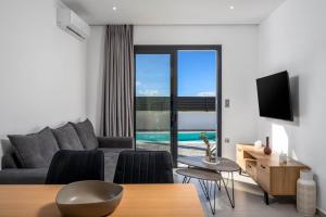 a living room with a couch and a table at Villa Salty Sun 7 in Kremasti