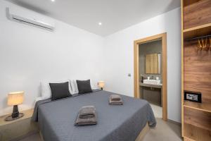 a bedroom with a bed with two towels on it at Villa Salty Sun 7 in Kremasti +16 photos