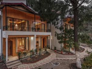 a large house with a balcony and a tree at ELIVAAS Signature Pine view resort in Sabāthu