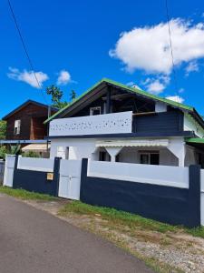 a house with a blue and white fence at Loft haut de villa in Baie-Mahault