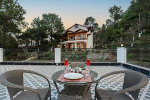 a table and chairs on a patio with a house at ELIVAAS Signature Pine view resort in Sabāthu
