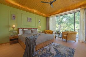 a bedroom with a large bed and a large window at ELIVAAS Signature Pine view resort in Sabāthu +78 photos