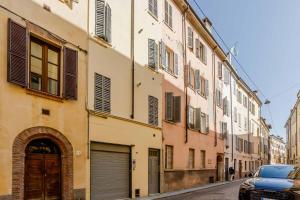 a street with a building with a car parked next to it at Borgo Riccio - Nice place in Parma in Parma