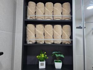 ein Handtuchhalter mit zusammengerollten Handtüchern im Badezimmer in der Unterkunft Gate 303 in Seoul + 22 Fotos