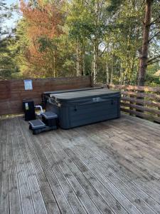 a large hot tub sitting on a wooden deck at Happy Ever After Lodge in Morpeth