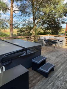a ping pong table and two stools on a deck at Happy Ever After Lodge in Morpeth