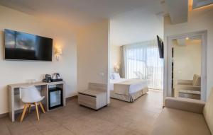 a hotel room with a bed and a television on the wall at Barceló Santiago - Adults Only in Puerto de Santiago