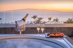 a bath tub with a bottle of champagne and wine glasses at Barceló Santiago - Adults Only in Puerto de Santiago +105 photos