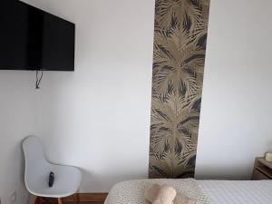 a bedroom with a bed and a television on a wall at Magnifique studio in Bressols