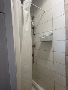 a shower with white curtains in a bathroom at Magnifique studio in Bressols +12 photos