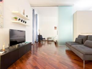 a living room with a couch and a flat screen tv at Voltiva House - in the Heart of Como Old Town in Como