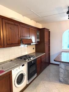a kitchen with a stove and a washing machine at Appartamento Trieste Airport in Ronchi dei Legionari