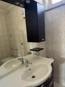a bathroom with a white sink and a mirror at Appartamento Trieste Airport in Ronchi dei Legionari +5 photos