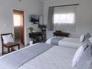 a hotel room with two beds and a television at Zu Hause in Piet Retief