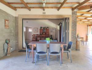 a dining room with a wooden table and chairs at Zu Hause in Piet Retief