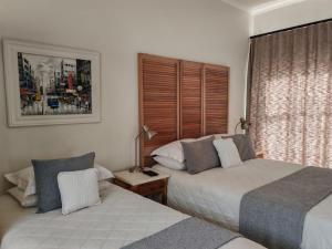 a bedroom with two beds and a window at Zu Hause in Piet Retief