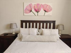 a bedroom with a bed with pink flowers on the wall at Zu Hause in Piet Retief +15 photos
