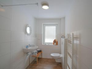 a white bathroom with a toilet and a sink at Mor Mor Hus in Böhl +19 photos