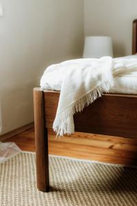 a bed with a white blanket on top of it at Katrina Summer House in Jūrmalciems +62 photos