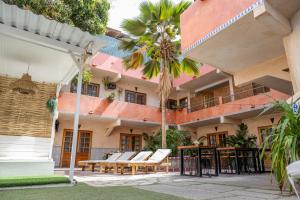 a courtyard of a house with chairs and palm trees at Casa Mara Dakar in Dakar