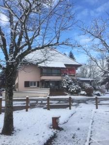 a house covered in snow in front of a fence at The Originals City, Hôtel Rey du Mont Sion, Saint-Julien-en-Genevois Sud in Saint-Blaise