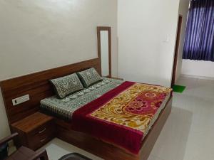 ein Schlafzimmer mit einem Bett mit hölzernem Kopfteil und Kissen in der Unterkunft Hotel GR Palace in Sheodāspura