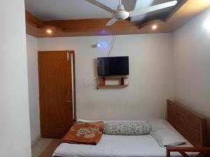 a room with a bed and a flat screen tv on the wall at Hotel Sikder-02 Residential in Dhaka