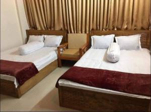 a bedroom with two beds and a chair at Hotel Sikder-02 Residential in Dhaka