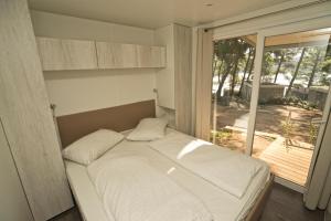 a bedroom with a bed and a large window at Mobile Homes Camping Kovačine in Cres +60 photos