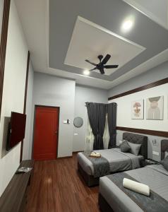 a bedroom with two beds and a ceiling fan at D'Anjung Cottage Paka in Paka