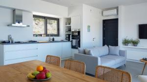 a kitchen and living room with a table with fruit on it at Villa Anna in Paleros