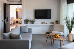 a living room with two couches and a tv at Villa Anna in Paleros