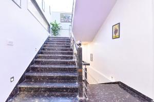 eine Treppe in einem Haus mit schwarzen Stufen in der Unterkunft FabHotel D3 - Vaishali Nagar in Jaipur + 49 Fotos