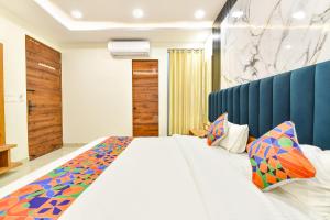 ein Schlafzimmer mit einem großen weißen Bett und bunten Kissen in der Unterkunft FabHotel D3 - Vaishali Nagar in Jaipur