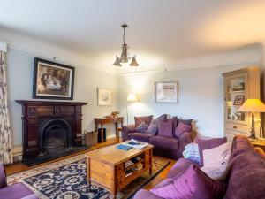 a living room with purple couches and a fireplace at The Convent Leenane in Leenaun