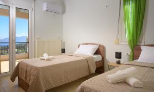 a hotel room with two beds and a balcony at Gi & Vi House in Agios Nikolaos