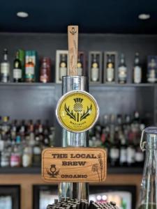 a bar with a sign on the top of a glass at Westend Hotel & Bar in Nairn