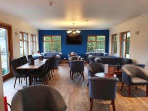 a dining room with chairs and tables and blue walls at Westend Hotel & Bar in Nairn