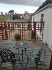 a patio with a table and chairs on a deck at Westend Hotel & Bar in Nairn