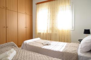 a bedroom with two beds and a window at Gi & Vi House in Agios Nikolaos +14 photos