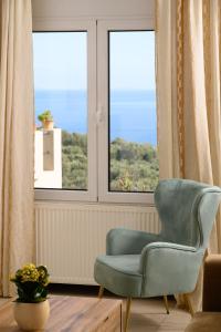 a blue chair in a room with a window at Gi & Vi House in Agios Nikolaos